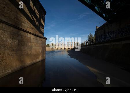 Pont romain au-dessus de la rivière Albarregas vu du canal. Aqueduc de Merida Los Milagros au fond, Extremadura, Espagne Banque D'Images