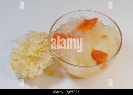 Plat sucré de neige double bouillie ou de champignon blanc avec papaye dans un bol en verre, avec Tremella fuciformis séché, sur blanc Banque D'Images