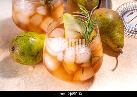 Boisson fruitée à l'alcool, cocktail doux de poire froide avec rhum, liqueur, anis et brin de romarin, garni de poire en tranches Banque D'Images