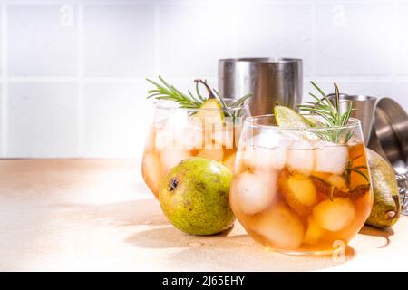 Boisson fruitée à l'alcool, cocktail doux de poire froide avec rhum, liqueur, anis et brin de romarin, garni de poire en tranches Banque D'Images