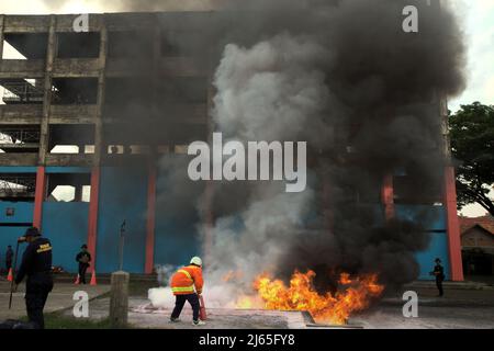 Un candidat exécutant une technique de lutte contre l'incendie au cours d'une compétition organisée entre des concurrents de tous les lieux d'affectation à Jakarta, à Cipayung, dans l'est de Jakarta, Jakarta, Indonésie. Banque D'Images