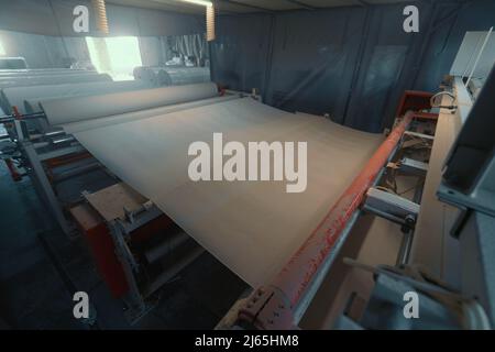 Machine qui produit du papier à partir de papier recyclé en grands rouleaux. Fabrication de papier toilette et d'autres produits en papier en usine. Banque D'Images
