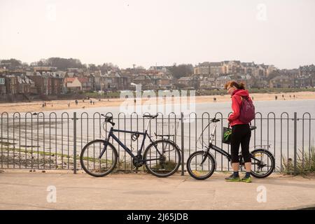 Une femme debout à côté d'un vélo pliant à North Berwick Banque D'Images