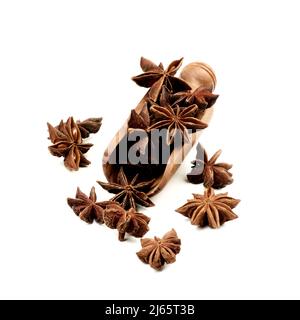 Étoiles d'anis séchées épicées dans une cuillère en bois isolée sur fond blanc Banque D'Images