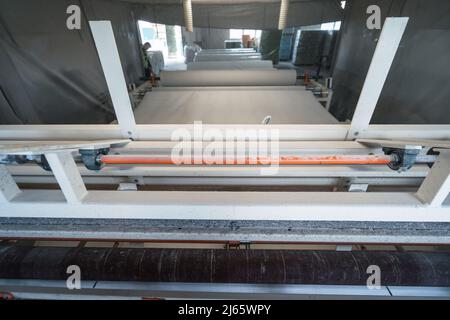 Machine qui produit du papier à partir de papier recyclé en grands rouleaux. Fabrication de papier toilette et d'autres produits en papier en usine. Banque D'Images