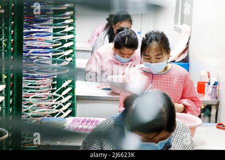 SUQIAN, CHINE - le 28 AVRIL 2022 - les travailleurs pressent les commandes lors d'un atelier de raquette de badminton en fibre de carbone haut de gamme à Suqian, province de Jiangsu en Chine orientale Banque D'Images