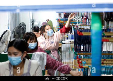 SUQIAN, CHINE - le 28 AVRIL 2022 - les travailleurs pressent les commandes lors d'un atelier de raquette de badminton en fibre de carbone haut de gamme à Suqian, province de Jiangsu en Chine orientale Banque D'Images