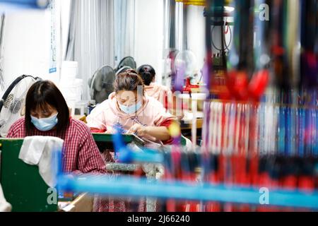 SUQIAN, CHINE - le 28 AVRIL 2022 - les travailleurs pressent les commandes lors d'un atelier de raquette de badminton en fibre de carbone haut de gamme à Suqian, province de Jiangsu en Chine orientale Banque D'Images