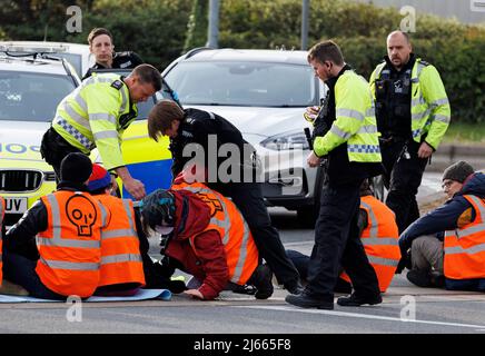 Cobham, Royaume-Uni. 28th avril 2022. La police tente de retirer les activistes de Just Stop Oil alors qu'ils bloquent la station-service de Cobham Services sur le M25 à Surrey. Les manifestants du groupe, une branche de la rébellion des extinction, ont récemment occupé un certain nombre d'installations de traitement du pétrole afin de souligner leur demande que le gouvernement arrête de nouveaux projets pétroliers et gaziers. Crédit photo: Ben Cawthra/Sipa USA **NO UK SALES** crédit: SIPA USA/Alay Live News Banque D'Images