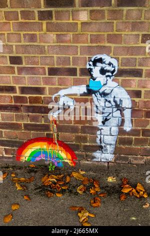 Fresque d'un tout-petit dans un masque pour le visage arroser un arc-en-ciel dans le style de Banksy sur un mur de jardin, Addington, Surrey, Angleterre, novembre 2021 Banque D'Images