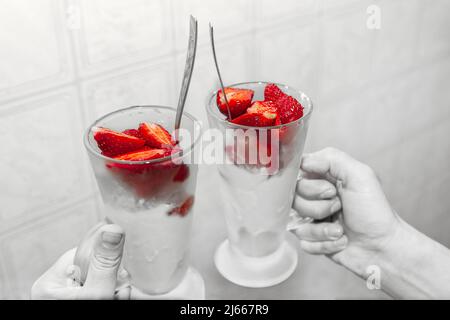 Fraises à la crème glacée dans la tasse . Dessert sain et savoureux dans la main Banque D'Images