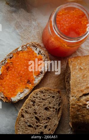 Sandwich au caviar de saumon rouge, fromage cottage, pain de grain entier sur planche à découper en bois. Concept de restaurant. Produit pour stimuler l'immunité sys Banque D'Images