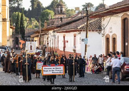 Les pénitents à capuchon catholiques romains portant des capirotes traditionnels portent une statue de Jésus-Christ lors de la procession du silence en célébration du Saint samedi, 16 avril 2022 à Patzcuaro, Michoacan, Mexique. La petite ville indigène conserve les traditions de la domination coloniale espagnole, y compris la confraternité des pénitents pendant la semaine sainte. Banque D'Images