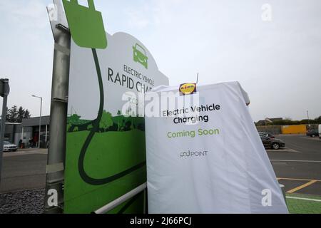 Lidl Supermarket car Park, Montrose, Angus, Écosse, Royaume-Uni. Installation d'un point de chargement de véhicule électrique dans le parking, en cours d'installation avec couvercle sur le chargeur, dites « chargement de véhicule électrique bientôt disponible » Banque D'Images