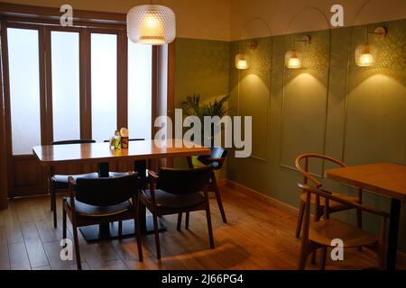 Tables et chaises en bois dans un café, un bureau ou une chambre vide. Design élégant, style vintage. Restaurant fermé, isolement strict dû au covid. Banque D'Images