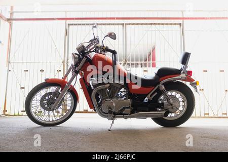 Moto classique ou vélo dans le parking près du garage. Banque D'Images