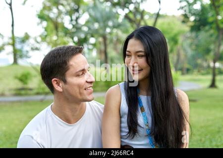 Gros plan d'un couple multiethnique souriant ensemble dans un parc Banque D'Images