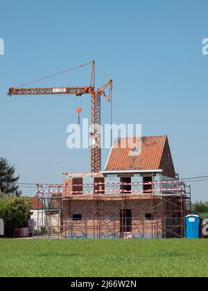 Sint Gillis Waas, Belgique, le 24 avril 2022, la construction d'une maison autour d'une maison existante tout en préservant l'ancien toit avec un échafaudage et c Banque D'Images