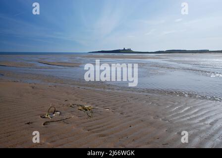 Image de style panoramique montrant le château historique de Dunstanburgh à l'horizon avec le premier plan de la plage ouverte menant à l'œil de la base au château Banque D'Images