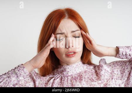 femme souffrant de maux de tête ou de migraine massant ses temples pour soulager la douleur Banque D'Images