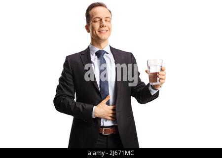 Homme d'affaires satisfait avec des yeux fermés tenant un verre d'eau isolé sur fond blanc Banque D'Images