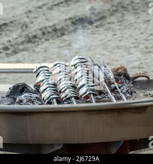 Cuisine typique de la côte andalouse: Sardines rôtisant par un feu de charbon dans un bateau Banque D'Images