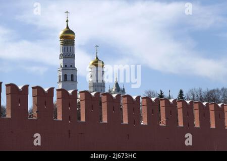 Ivan la Grande Tour de la cloche avec des coupoles d'or derrière le mur de brique rouge du Kremlin le jour ensoleillé Banque D'Images