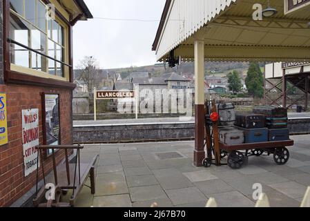 Chariot à bagages vintage avec malles et valises sur la plate-forme de la gare de Llangollen sur le chemin de fer Llangollen Heritage conservé, pays de Galles, Royaume-Uni Banque D'Images