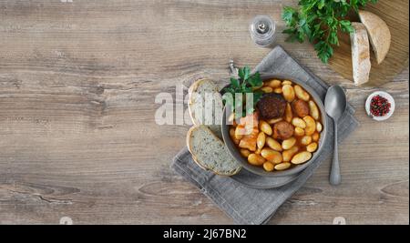 Fabada typiquement espagnole asturiana sur une table en bois avec du pain. Vue de dessus, espace de copie Banque D'Images