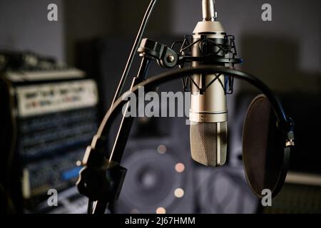 Horizontal pas de personne prise de vue du microphone à condensateur avec disque filtre pop dans un studio d'enregistrement moderne Banque D'Images
