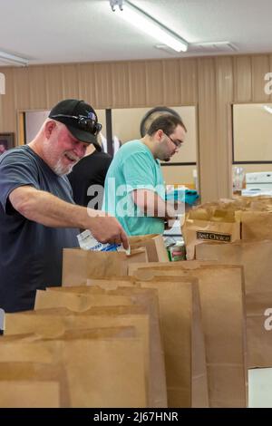 Chetopa, Kansas - les bénévoles du centre communautaire Mae Lessley emballez des sacs de nourriture pour les familles dans le besoin. Banque D'Images