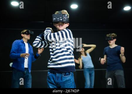 Emotive Tween boy jouant à vr jeu avec la famille Banque D'Images