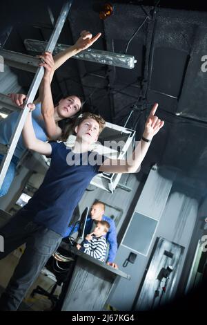 Femme avec un fils adolescent pointant vers quelque chose dans la salle de quête Banque D'Images