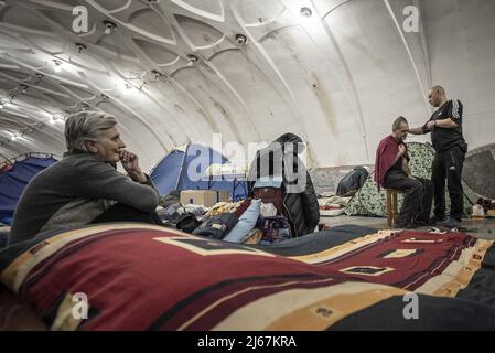 Kharkiv, Ukraine. 28th avril 2022. Sergii Virchenko, 42 ans, à droite, coupe les cheveux pour Sergueï Gerasimenko, 50 alors qu'ils survivent avec des centaines d'autres dans la station de métro après que leur maison ait été détruite après des jours de pilonnage par les Russes à Kharkiv, Ukraine, le jeudi 28 avril 2022. La Chambre des représentants a adopté un projet de loi demandant au président Joe Biden de saisir les actifs d'oligarques russes sanctionnés et des utiliser pour profiter à l'Ukraine. Le projet de loi a été adopté, mais huit députés ont voté contre la mesure Ñ quatre républicains et quatre démocrates. Photo de Ken Cedeno/UPI crédit: UPI/Alay Live News Banque D'Images