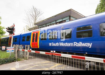 Un train South Western Railway passant par la boîte de signalisation Vine Road Level Crossing, Barnes, Londres, SW13, Angleterre, ROYAUME-UNI Banque D'Images