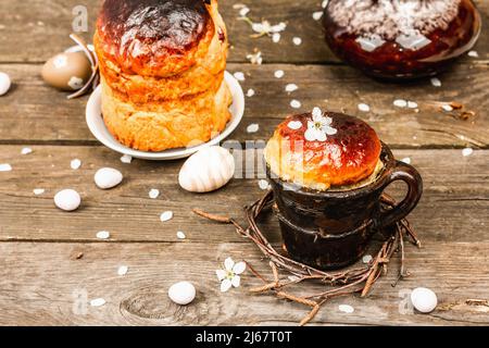 Gâteau traditionnel de Pâques dans un style rustique. Marmite vintage, branches de prune de cerise en fleur. Ancien fond en bois, carte de vœux Banque D'Images