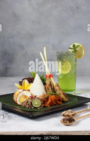 courge de citron glacé et délicieux nasi épicé bali avec œuf de piment, satay de poulet et salade végétagie sur fond blanc d'assiette noire Banque D'Images