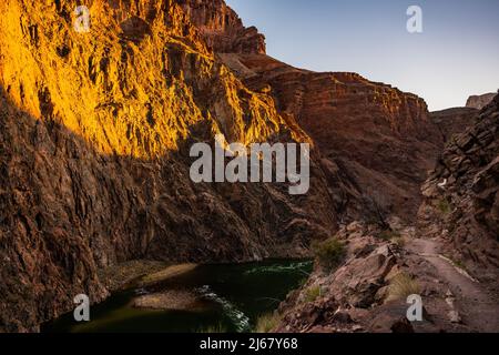 Le soleil commence à remplir le Grand Canyon de lumière sous Bright Angel Trail Banque D'Images