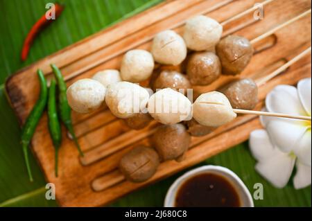 Vue de dessus, boulettes de viande asiatiques thaïlandaises grillées et boulettes de porc servies avec du Chili et une sauce spéciale. Cuisine thaïlandaise de rue Banque D'Images