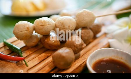 Gros plan, boulettes de viande et boulettes de porc asiatiques grillées thaïlandaises sur brochette avec sauce spéciale épicée au tamarin. Banque D'Images