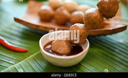 Gros plan, De savoureux boulettes de viande grillées thaïlandaises dans une sauce spéciale. Cuisine thaïlandaise asiatique de rue. Banque D'Images