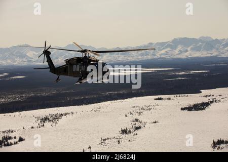 Les gardes nationaux de l'Armée de l'Alaska avec le bataillon de soutien général de l'aviation 2-211th se déplacent de la base interarmées Elmendorf-Richardson à Nome, en Alaska, via l'hélicoptère UH-60L Black Hawk le 11 avril 2022. Les hélicoptères UH-60L Black Hawk resteront à Nome pour la Golf Company, détachement 1, 2-211th GSAB pour effectuer un entraînement annuel et de l'aide à River Watch au besoin ce printemps. En cas d'inondations importantes ou d'autres situations d'urgence dans les environs, les hélicoptères fourniront un soutien à la demande de l'État. (Photo de la Garde nationale de l’Alaska par 1st Lt. Balinda O’Neal) Banque D'Images