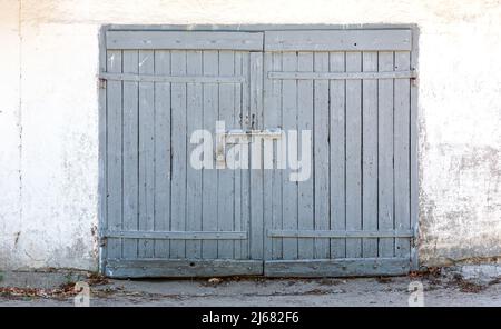 ancienne porte fermée en bois sur un mur en plâtre recouvert de peinture blanche Banque D'Images