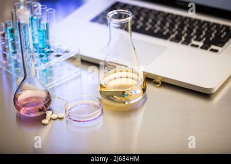 Pilules et équipement chimique sur la table d'opération du laboratoire de tests de médicaments - photo de stock Banque D'Images