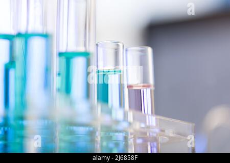 Tubes à essai soigneusement disposés contenant du réactif bleu et rose en laboratoire de chimie - photo de stock Banque D'Images