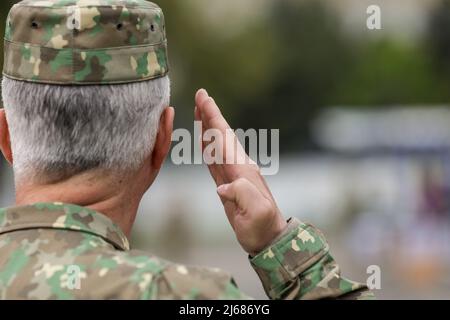 Bucarest, Roumanie - 28 avril 2022 : un soldat des forces terrestres roumaines salue lors d'une cérémonie publique. Banque D'Images