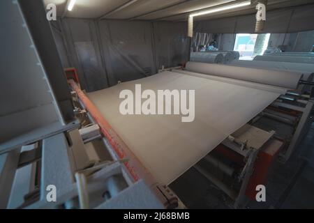 Machine qui produit du papier à partir de papier recyclé en grands rouleaux. Fabrication de papier toilette et d'autres produits en papier en usine. Banque D'Images