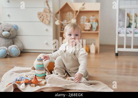 Un merveilleux petit garçon aux yeux bleus. Enfant jouant avec des jouets en pépinière. Développement précoce, maternelle, maternelle, salle de jeux. Journée des enfants, le Da de la mère Banque D'Images