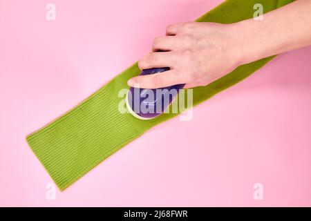 Un rasoir en tissu qui utilise un rasoir en tissu élimine les pastilles de tissu des vêtements Banque D'Images