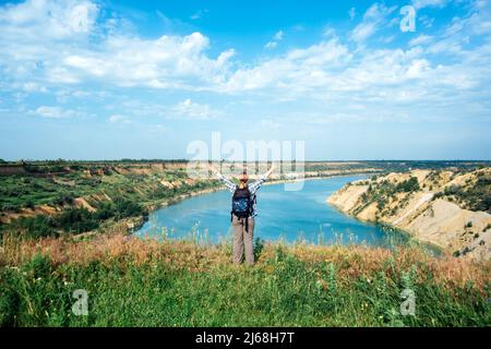 Voyage solo, voyage wanderlust, vacances d'été, tourisme écologique, randonnée extérieure. Touriste femelle avec un sac à dos sur le bord de la falaise au bord du lac Banque D'Images